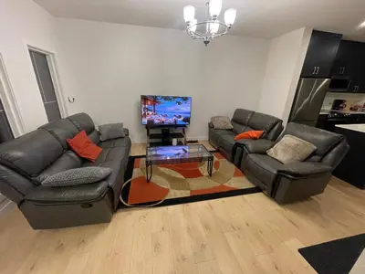 a living room with two couches and a flat screen tv at Bedroom private Bathroom in Upland in Edmonton
