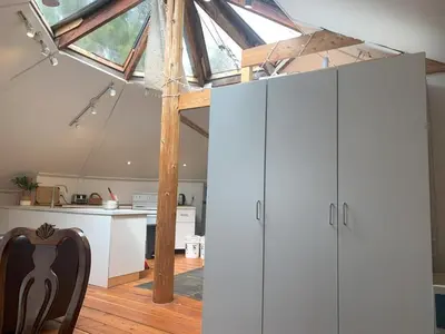 an attic kitchen with white cabinets and a glass roof at Cozy and rustic cabin in Nelson