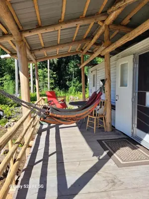 a hammock on a porch of a house at Rara's secret nest in Aiyansh
