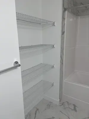 a white closet with empty shelves in it at Westminister Manor in Calgary