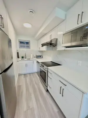 a large white kitchen with white cabinets and appliances at Perfect Vancouver Travel Hub for Couples or Family in Vancouver