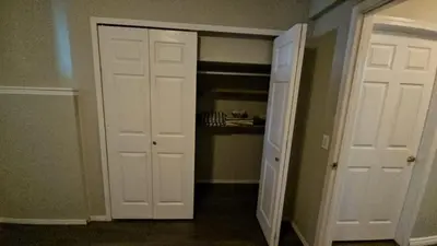 a room with two white doors and a closet at Basement Appartment in Edmonton