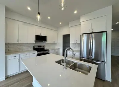 a kitchen with white cabinets and a stainless steel refrigerator at ED Phonix