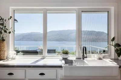 a kitchen with a sink and a large window at Magical Lake View in Peachland