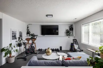 a living room with a couch and a tv at Magical Lake View in Peachland