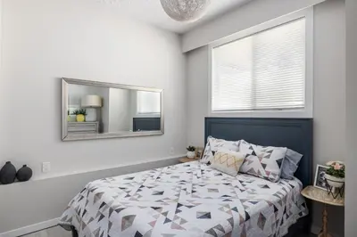a bedroom with a bed and a mirror at Magical Lake View in Peachland