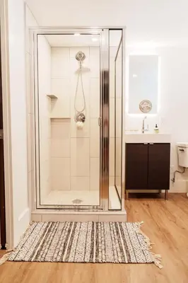 a shower with a glass door in a bathroom at 4 Bed Home Along River Near DT AC Hot Tub in Calgary