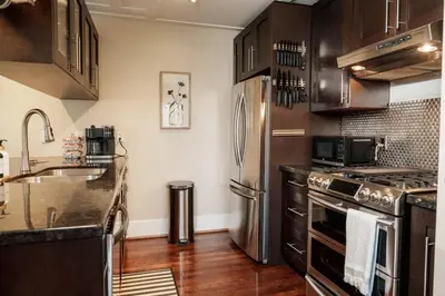 a kitchen with stainless steel appliances and wooden cabinets at 4 Bed Home Along River Near DT AC Hot Tub in Calgary