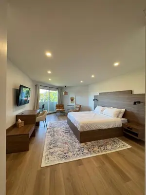 a bedroom with a large bed and a living room at Hotel 19 in Port Hardy