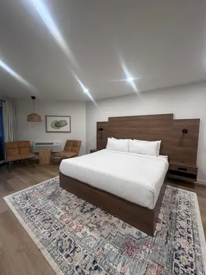 a bedroom with a large white bed and a rug at Hotel 19 in Port Hardy