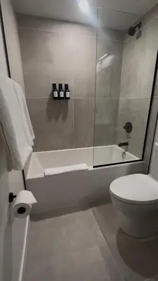 a bathroom with a toilet and a glass shower at Hotel 19 in Port Hardy