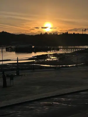 a sunset over a body of water with the sun setting at Hotel 19 in Port Hardy