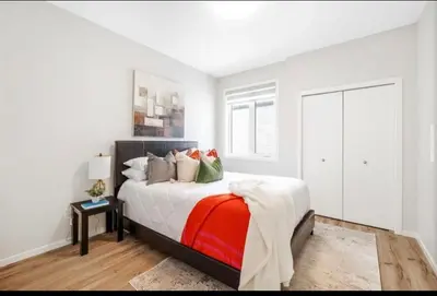 a bedroom with a bed with a red and white blanket at Magnificent Stylish Escape in Bélanger