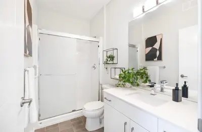 a white bathroom with a shower and a toilet at Magnificent Stylish Escape in Bélanger