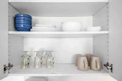 a shelf with glass jars and plates on it at Garden Suite near Jericho Beach in Vancouver