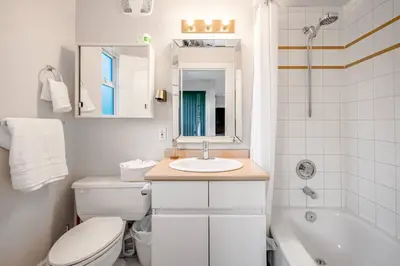 a bathroom with a toilet and a sink and a tub at Garden Suite near Jericho Beach in Vancouver