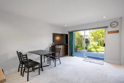 a dining room with a table and chairs and a clock at Garden Suite near Jericho Beach in Vancouver