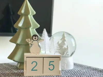 a table with a clock with trees and a snow globe at Top Floor Mountain View Escape in Canmore