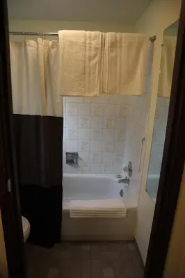 a bathroom with a tub and a shower and a toilet at Taylor Lake Resort BC in Lone Butte
