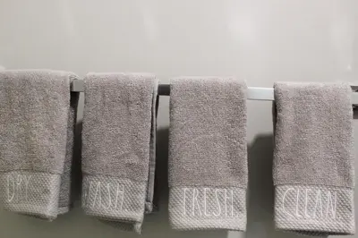 four towels hanging on a towel rack in a bathroom at Cozy 2-Bedroom Walkout Basement Suite in Calgary