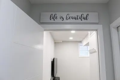 a sign above a door that reads life is beautiful at Cozy 2-Bedroom Walkout Basement Suite in Calgary
