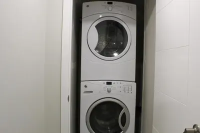 a washer and dryer in a small room at Cozy 2-Bedroom Walkout Basement Suite in Calgary