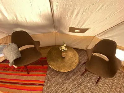 three chairs and a table in a tent at Tree Top Sanctuary Cowichan Valley in Duncan