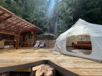 a white tent on a wooden deck with a table at Tree Top Sanctuary Cowichan Valley in Duncan