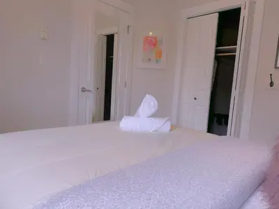a bedroom with a white bed with a white pillow on it at Canmore Top Floor Loft-Style Retreat in Canmore