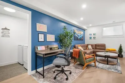 a living room with a blue accent wall at Meadowstone Suite 3BD 3 TVs Near Spruce Meadows in Calgary