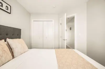 a white bedroom with a large bed and a closet at Large Single Family 3 Bedroom House with Air Conditioner, Garage and Lake View in Calgary
