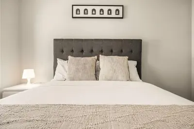 a bedroom with a large bed with white sheets and pillows at Large Single Family 3 Bedroom House with Air Conditioner, Garage and Lake View in Calgary