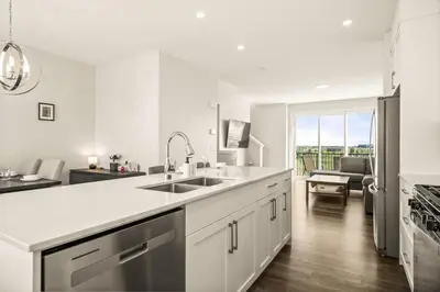 a white kitchen with a sink and a stove at Large Single Family 3 Bedroom House with Air Conditioner, Garage and Lake View in Calgary