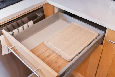 a drawer in a kitchen with a cutting board in it at Play & Stay - Downtown Sleeps 10 in Edmonton