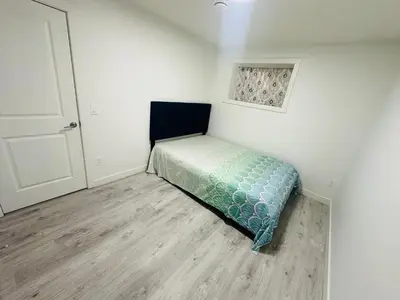 a small bedroom with a bed in the corner at 2 bedroom Basement Suite in Calgary