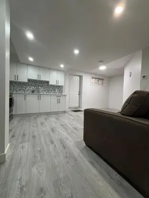 an empty living room with a couch and a kitchen at 2 bedroom Basement Suite in Calgary