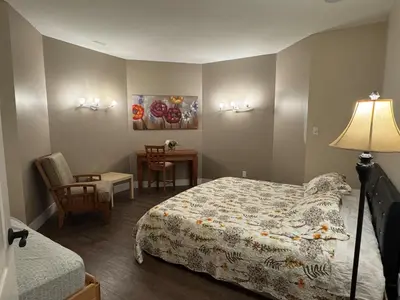 a bedroom with a bed and a table and a lamp at Relaxing Lakeview 2 bedroom entire suite in Kelowna