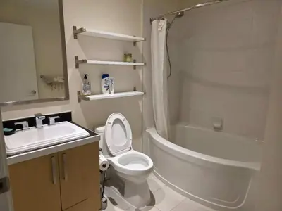 a bathroom with a toilet and a tub and a sink at Private Room in Vibrant Vancouver - with share living room and kitchen in Vancouver