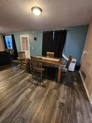 a dining room with a wooden table and chairs at Cozy Bungalow