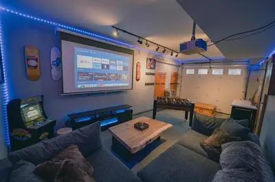 a living room with a couch and a large screen at Snow Reason A in Big White