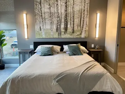a bedroom with a large bed with a painting on the wall at Parksville Townhome 2 bedroom pool gym in Parksville