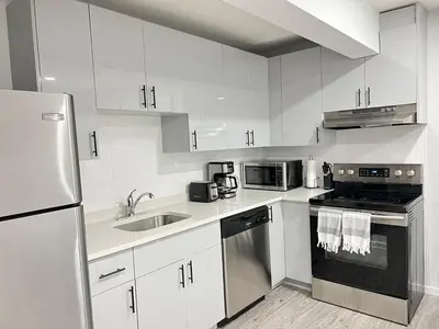 a kitchen with white cabinets and stainless steel appliances at 1-BR Suite with Private entrance near Restaurants, Shops, Local Amenities in Edmonton