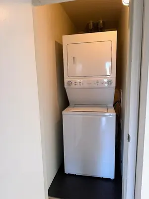 a small white refrigerator with a microwave on top of it at Mid-Century Modern Apartment at Horner Park in Victoria