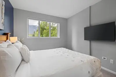a bedroom with a white bed and a window at 2BR in Deer Lodge, Epic Location, Private Covered Patio, Free Parking in Whistler