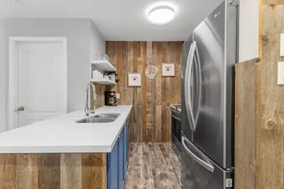 a kitchen with a refrigerator and a sink at 2BR in Deer Lodge, Epic Location, Private Covered Patio, Free Parking in Whistler