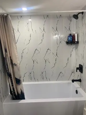 a bathroom with a tub and a shower curtain at Modern 1BR Entire Suite Near Airport in Calgary