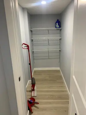a hallway with a vacuum cleaner and shelves at Modern 1BR Entire Suite Near Airport in Calgary