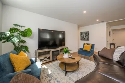 a living room with a couch and a tv at Forest Haven on the Ridge in Prince George