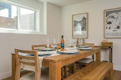 a dining room with a wooden table and chairs at Forest Haven on the Ridge in Prince George