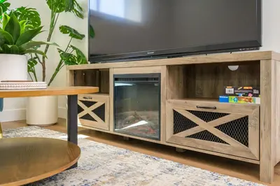 a fireplace in a wooden entertainment center with a television on top at Forest Haven on the Ridge in Prince George